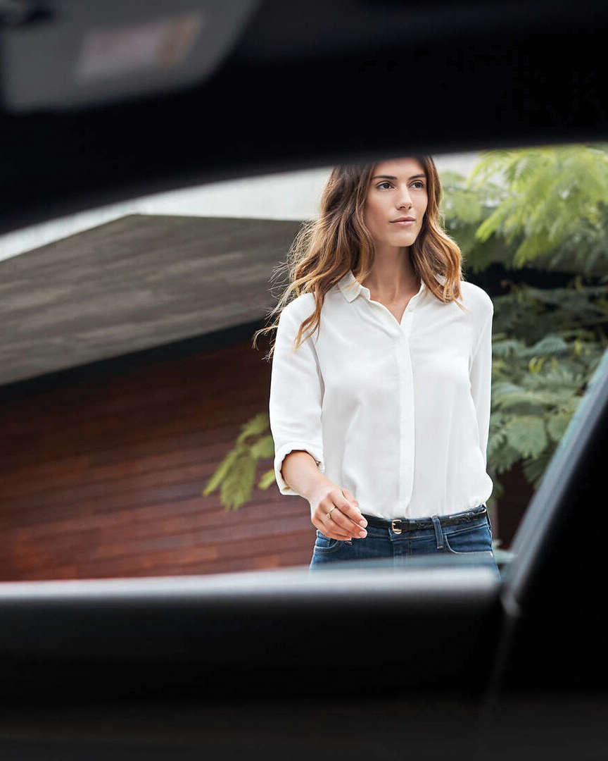 Молода жінка підходить до автомобіля Peugeot