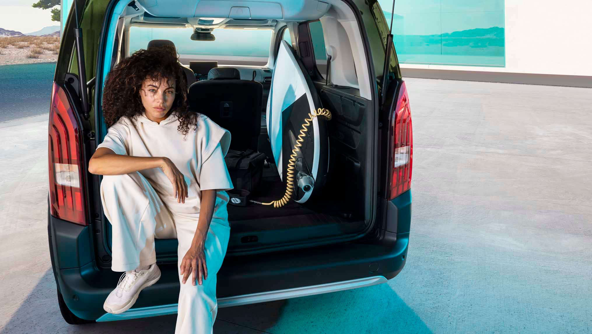 Жінка сидить у багажнику Peugeot e-Rifter